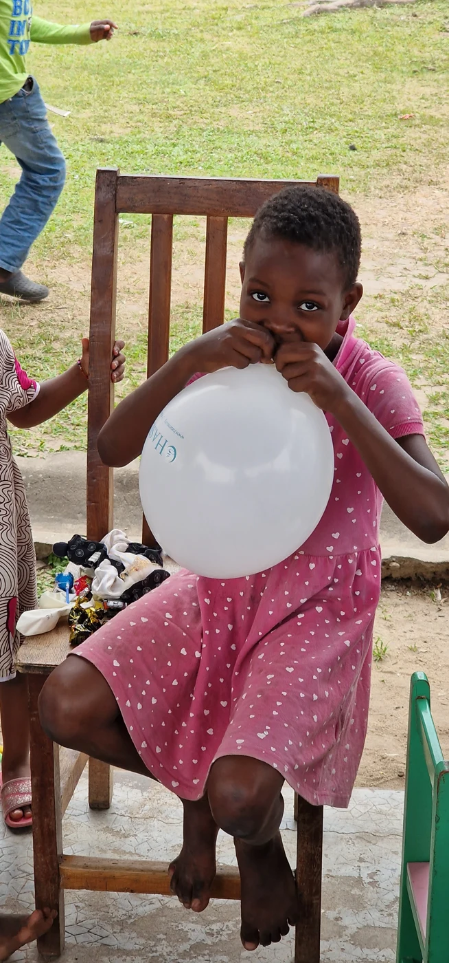 A child blowing up a balloon in Gabon